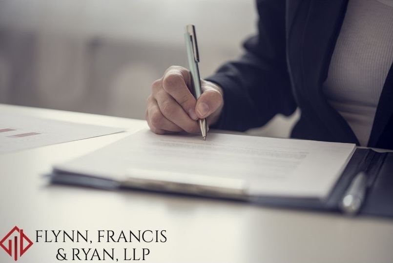 A women dressed in professional clothes writing at a desk