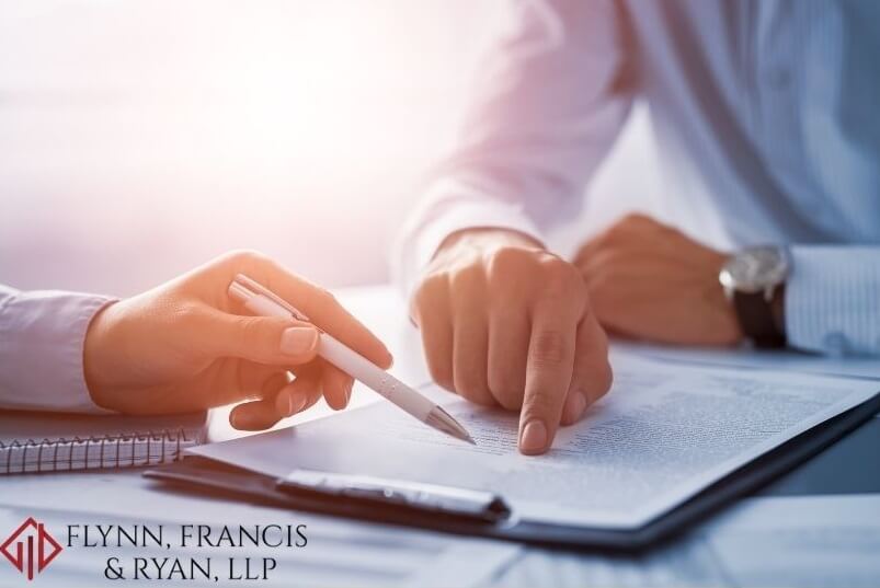 Two people pointing at a contract sitting at a desk